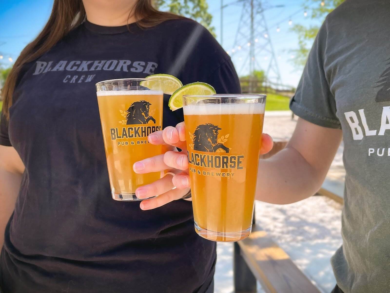 Two people holding up Blackhorse beers in Alcoa (in Maryville, TN).